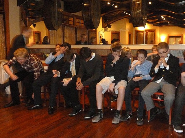 Boys imagining they're eating at a Chicago area bar mitzvah hypnosis show. 