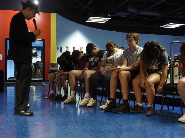 Row of seated students being hypnotized at a Chicago area graduation party