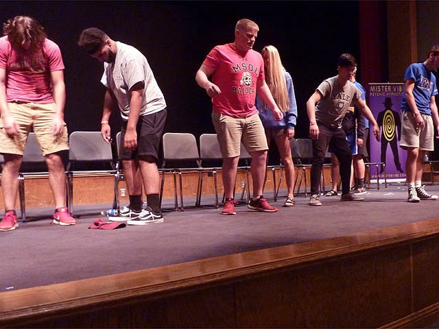 Students dance on stage at a Chicago area high school graduation hypnosis show.